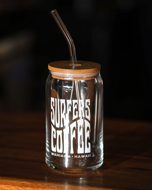 Glass tumbler with wooden lid and straw, featuring 'Surfers Coffee' branding on a dark background.