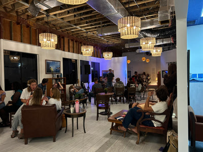 People sitting in a modern indoor setting with wooden furniture and decorative lighting.
